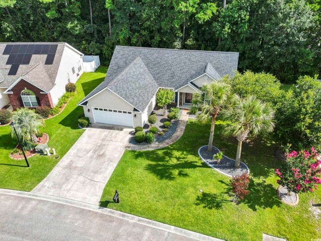 View of front facade featuring a garage, driveway, a front yard, and a shingled roof | Image 33