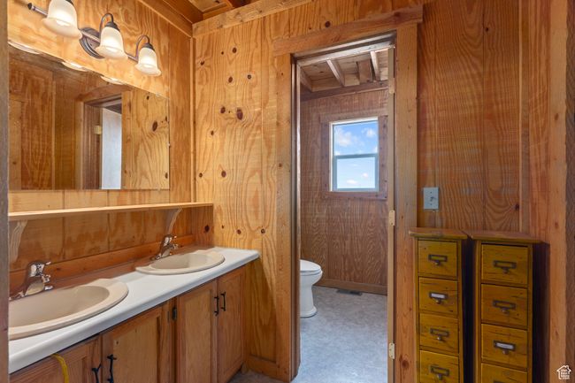 Bathroom with beam ceiling, wooden walls, doublevanity, and toilet | Image 16