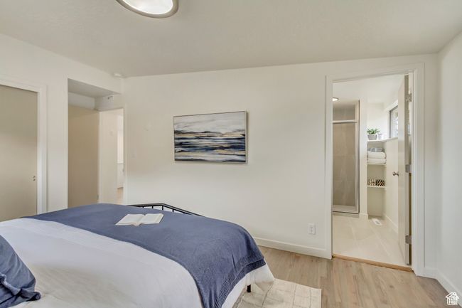 Bedroom with connected bathroom, baseboards, and light wood-type flooring | Image 12