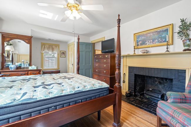 Bedroom featuring wood finished floors and a fireplace | Image 18