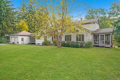 Obstructed view of property featuring a screened porch and a front lawn | Image 3