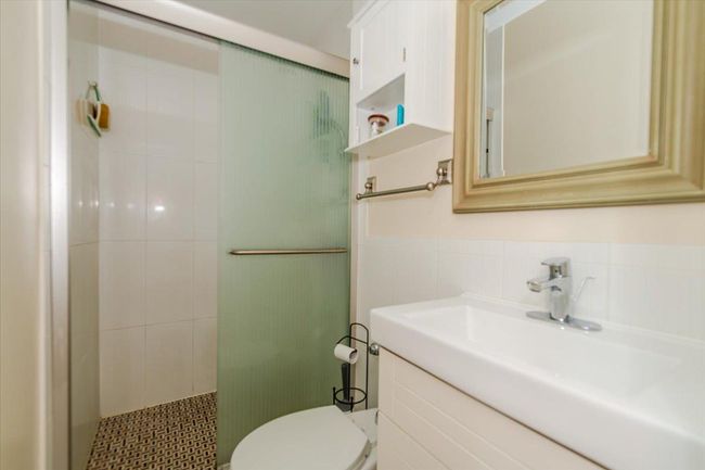 Bathroom featuring a shower stall, vanity, and tile walls | Image 12