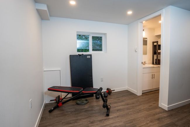 Exercise room featuring dark wood finished floors, baseboards, a sink, and recessed lighting | Image 28