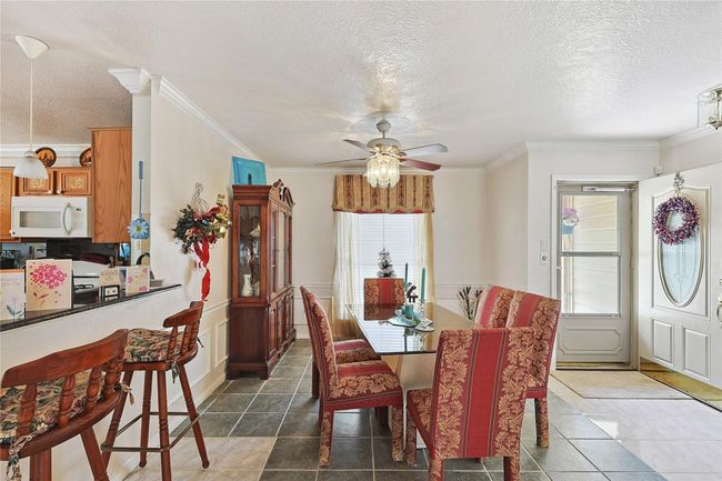 Elegant entry flows into the formal dining room, featuring natural light, crown molding, and space to host family gatherings or dinner parties. | Image 6