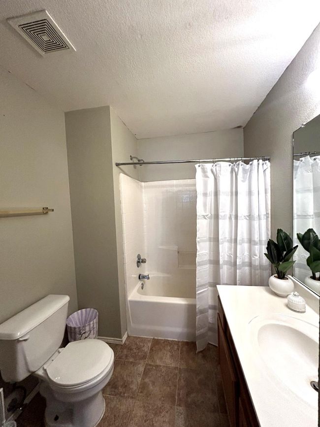 Full bath featuring vanity, shower / bathtub combination with curtain, and a textured ceiling | Image 12
