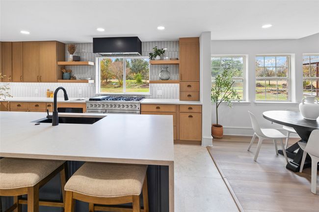 Kitchen with open shelves, wall chimney range hood, light countertops, stainless steel range, and recessed lighting | Image 18