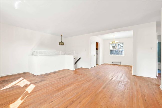 Empty room featuring a chandelier and light wood-style floors | Image 4
