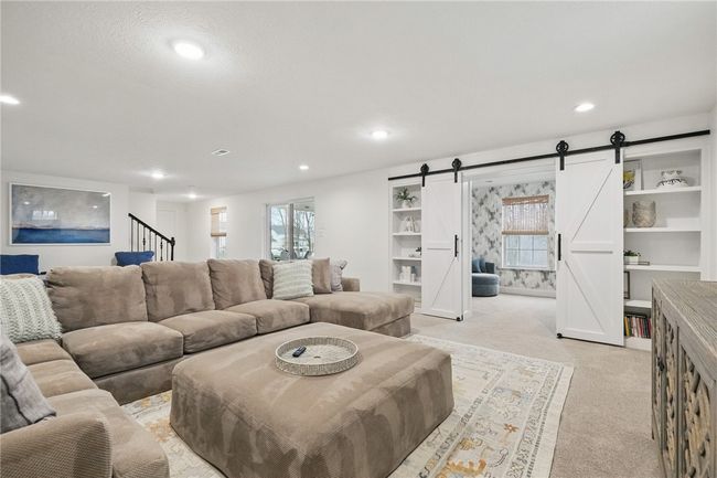 Expansive finished basement offering a versatile layout perfect for a media room, playroom, billiard room or entertaining space. Features recessed lighting, plush carpeting, and neutral tones throughout—complete with a walk-out door for easy outdoor access to lower level covered patio and added convenience. | Image 31