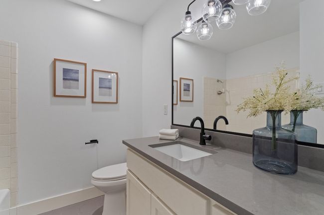 This full bathroom features quartz counters and a shower/tub combo. | Image 20