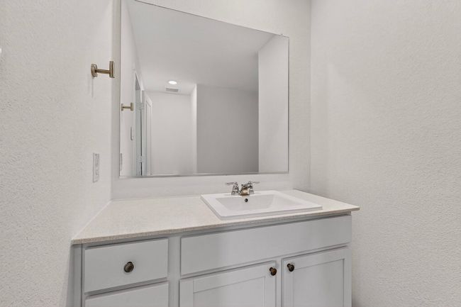 Bathroom featuring vanity and a textured wall | Image 19