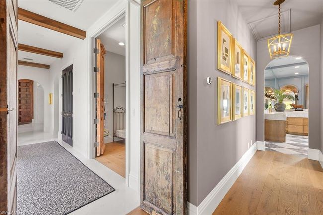 Corridor featuring arched walkways, visible vents, a chandelier, and light wood-style floors | Image 28