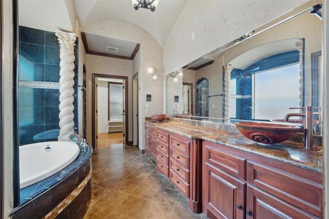 Bathroom with a bath, double vanity, crown molding, and tile patterned floors | Image 17