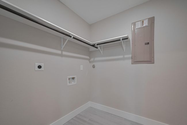 The laundry area is both functional and spacious, with room for full-size appliances and a built-in rack and overhead rod for streamlined organization. | Image 30