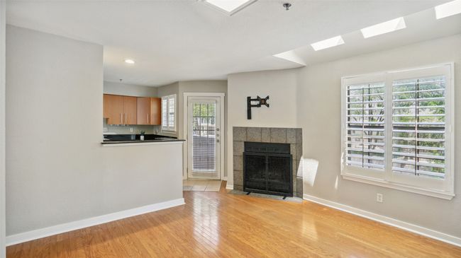 Unfurnished living room featuring baseboards, a skylight, light wood-style flooring, a fireplace, and recessed lighting | Image 4