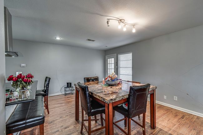 Dining space featuring visible vents, a textured ceiling, baseboards, and wood finished floors | Image 13