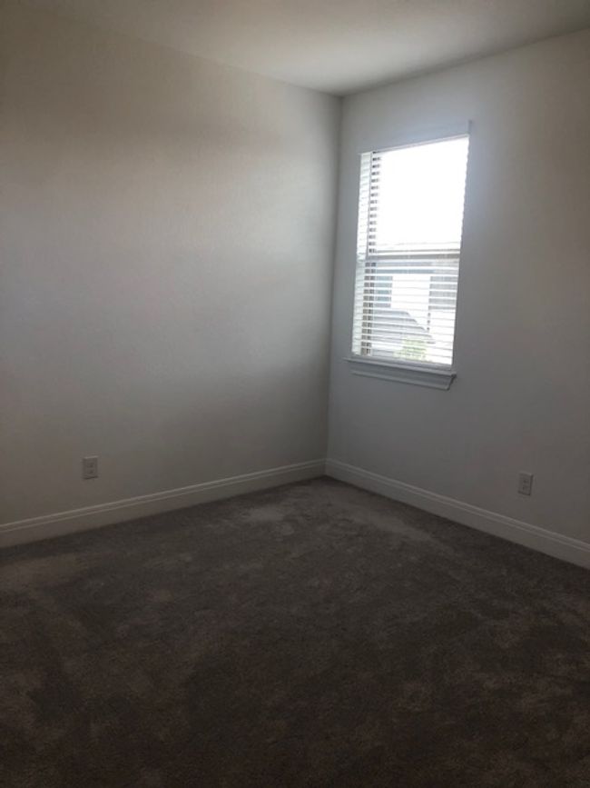 Spare room featuring dark carpet and baseboards | Image 24