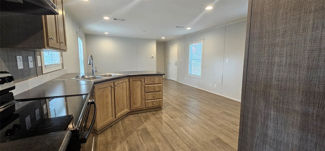 Kitchen with brown cabinetry, light wood-style floors, range with electric cooktop, extractor fan, and recessed lighting | Image 12