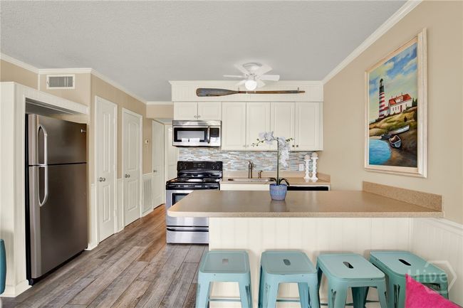 Full Sized Kitchen with Stainless Steel Appliances, Ceiling Height Cabinets, Island with Barstool Seating & Pantry. | Image 8