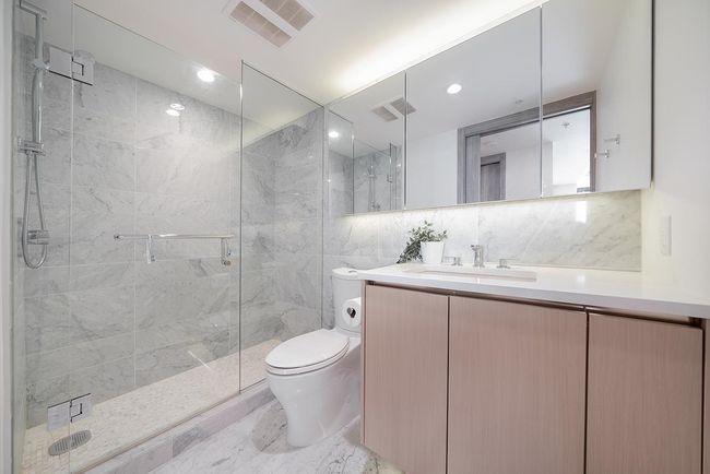 Full bathroom with toilet, vanity, a shower stall, tile walls, and decorative backsplash | Image 10