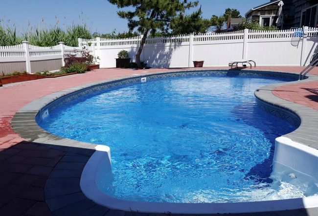 View of pool with a diving board, a fenced in pool, a fenced backyard, and a patio area | Image 17