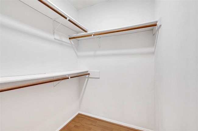 Expansive primary closet with ample hanging space and sleek finishes for organized storage. | Image 22