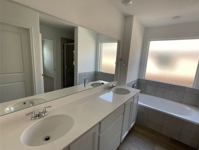 Full bathroom with a bath, a stall shower, wood finished floors, and double vanity | Image 23