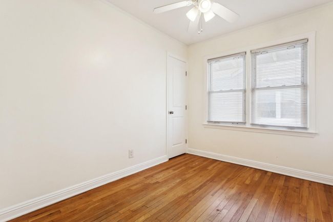 Empty room with light wood-type flooring, a ceiling fan, and baseboards | Image 14