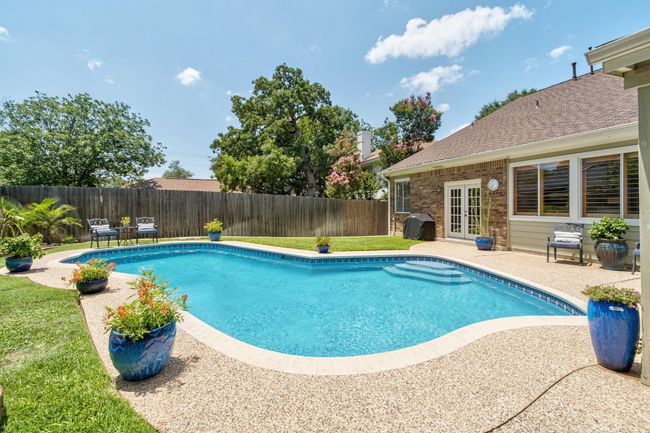 View of swimming pool featuring french doors, a fenced backyard, a patio, and grilling area | Image 25