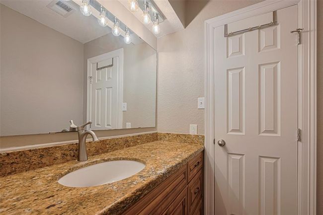 2nd bathroom features large granite vanity counters, custom lighting above large mirror, wood cabinets, and a tub/shower | Image 23