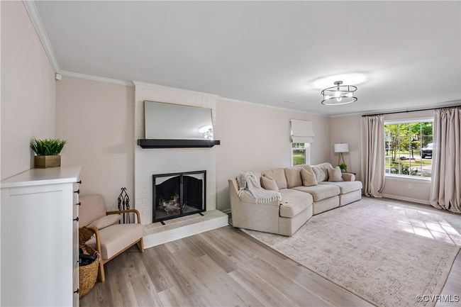 Living room featuring ornamental molding, light wood-style floors, and a fireplace | Image 9