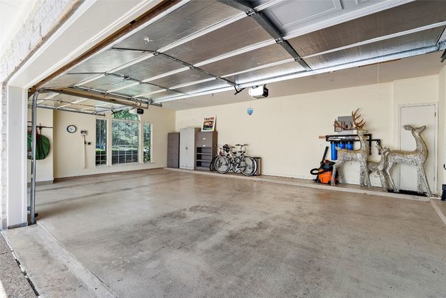 The garage is beautifully designed with large windows that bring in natural light, complimented by recessed lighting for a bright and functional space | Image 35