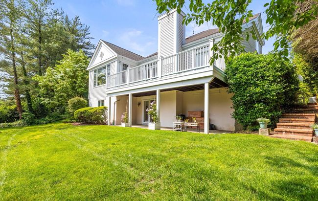 Back of property featuring a chimney, a yard, a wooden deck, and a patio | Image 39