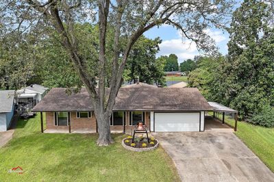 Ranch-style home with a garage, a front lawn, and a carport | Image 3