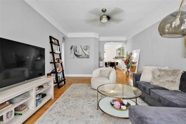 Living area featuring arched walkways, a ceiling fan, and baseboards | Image 15