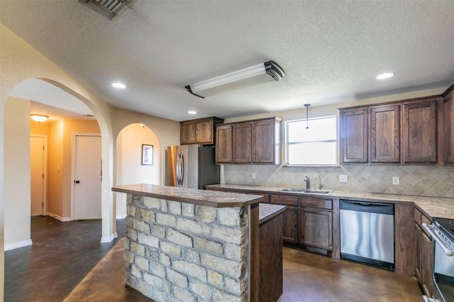 Kitchen with stainless steel appliances, visible vents, a sink, and backsplash | Image 7