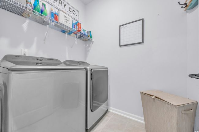 Laundry area with washer and dryer, baseboards, and light tile patterned flooring | Image 19