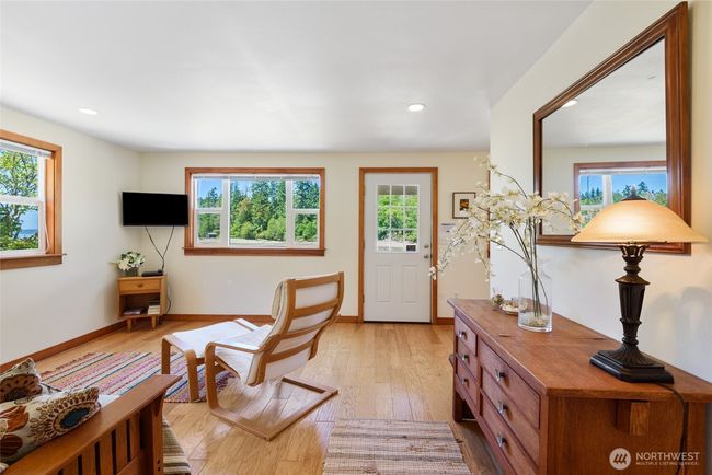 Enjoy the bright sitting room with views facing the water. | Image 19