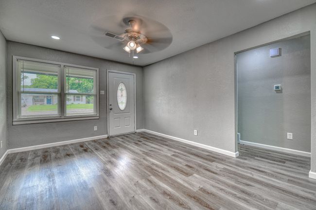 Foyer entrance with ceiling fan, wood finished floors, and a textured wall | Image 6