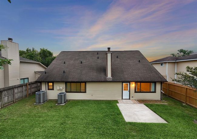 Spacious backyard features a well-maintained lawn, privacy fencing, and ample room for outdoor activities or a future pool addition. | Image 5