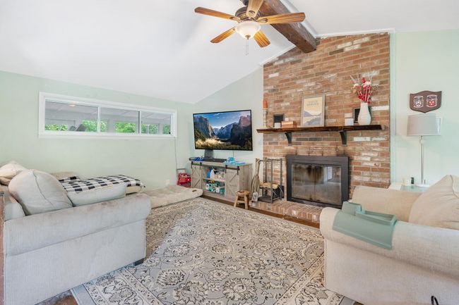 Living area featuring a ceiling fan, a fireplace, and wood finished floors | Image 17