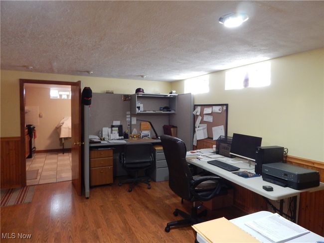 Office area within Recreation Room with wood-style flooring and a textured Ceiling & Glass Blocked Windows. | Image 23