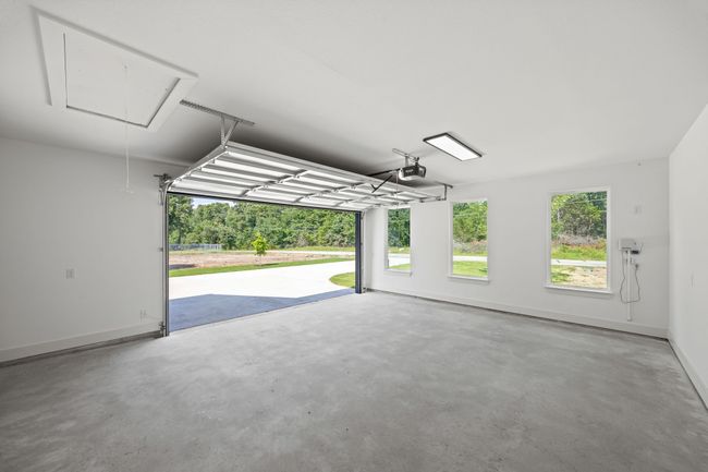 Garage with a garage door opener and baseboards | Image 31