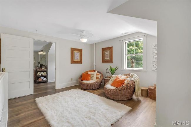 Living area with wood finished floors and a ceiling fan | Image 66