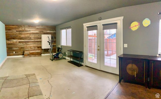 Interior space with fridge, wood walls, and french doors | Image 18