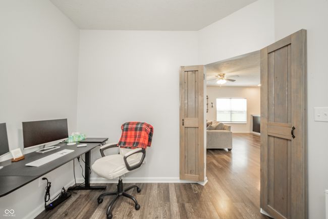 office space featuring wood finished floors, a ceiling fan, and baseboards | Image 13