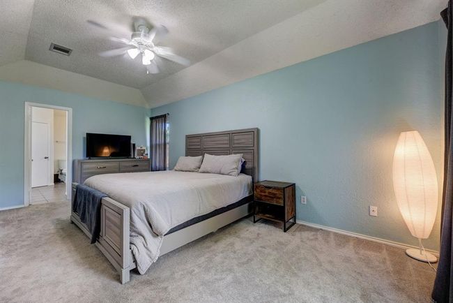 Bedroom featuring light colored carpet, vaulted ceiling, baseboards, and ceiling fan | Image 6