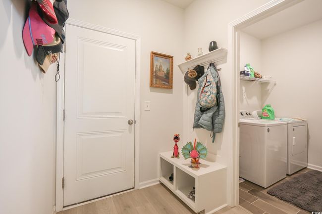 Mudroom featuring washing machine and dryer, light wood-type flooring, and baseboards | Image 22