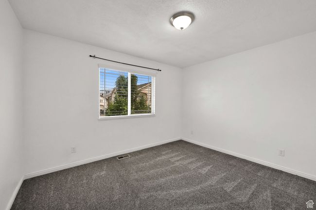 Unfurnished room featuring dark carpet and baseboards | Image 25