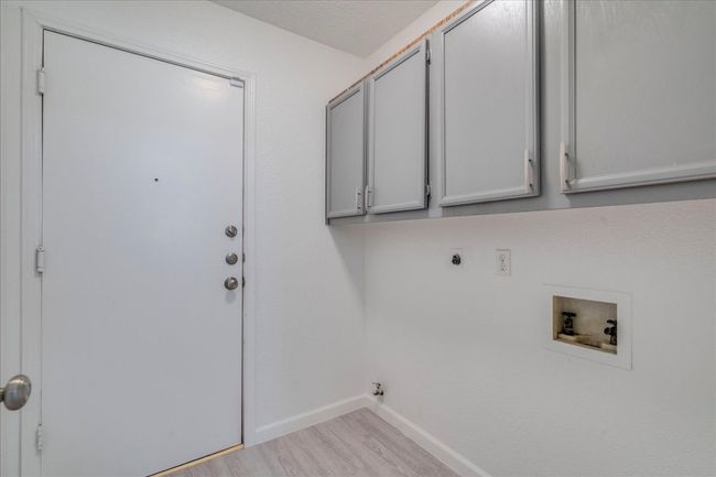 Washroom with cabinet space, washer hookup, electric dryer hookup, baseboards, and wood finished floors | Image 30