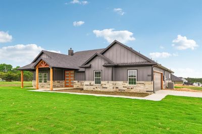 View of front of home featuring a front lawn, a garage, and central AC unit | Image 2